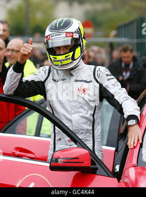 Il campione del mondo di Formula 1 Jenson Button si prepara a prendere i vincitori del concorso per un giro in una Mercedes sportiva durante una presentazione al centro commerciale Bluewater di Greenhitthe, Kent. Foto Stock