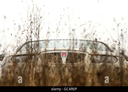 Una Rover 75 può essere vista attraverso le erbacce, mentre i vecchi edifici sono in disuso o demoliti mentre i nuovi sviluppi progrediscono presso LO stabilimento DI AUTOMOBILI MG Rover a Longbridge, Birmingham Foto Stock