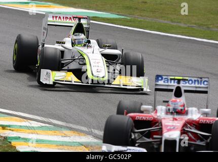 Jenson Button della Brawn GP (a sinistra) si fa strada attraverso il campo durante il Gran Premio del Brasile a Interlagos, San Paolo. Foto Stock