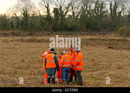 I membri della Commissione indipendente per la localizzazione delle vittime (ICLRC) esaminano i terreni utilizzando geofisica e digger dove si sospetta che i resti di Gerard Evans, provenienti da Armagh sud, siano sepolti, a Carrickrobin, Co Louth. Foto Stock