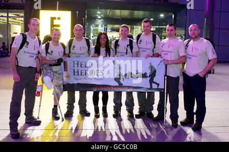 (Da sinistra a destra) Stuart Trow, John Sandford Hart, Tony Burbage, Natalie Fellowes, Jon le Galloudec, STU le Coulliard, Craig Lundberg e Andrew Larkey arrivano al Terminal 3 dell'aeroporto di Heathrow dove si uniranno a un gruppo di persone che partiranno per salire sul Monte Kilimanjaro in aiuto di Aiuto per Eroi. Foto Stock