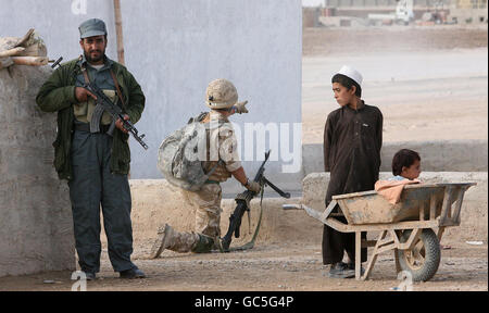 Un soldato britannico e un ufficiale di polizia nazionale afghano in pattuglia a Lashkar Gah vicino alla base di pattuglia Bolan, Afghanistan. Foto Stock