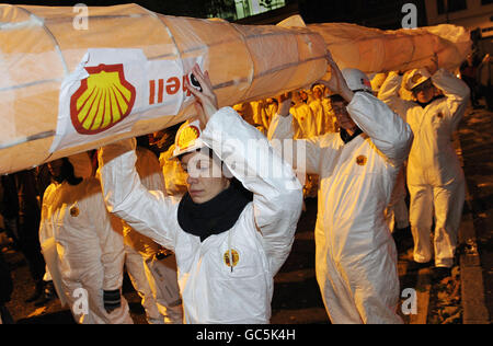 Gli attivisti ambientali organizzati da Amnesty International portano un tubo attraverso Hoxton per protestare contro le attività del gigante petrolifero Shell nel Delta del Niger. Foto Stock