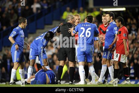 I giocatori di Chelsea e Manchester United discutono con l'arbitro Martin Atkinson Come Ricardo Carvalho di Chelsea (a sinistra) giace ferito sul campo Foto Stock