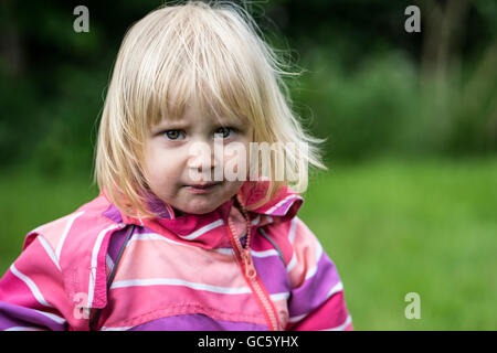 Triste o disorientati ragazza in piedi da solo in giardino Foto Stock