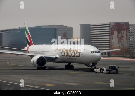 Un Emirates Boeing 777-300ER spinge indietro dalla porta all'Aeroporto Internazionale di Dubai Foto Stock