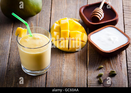 Bicchiere di mango lassi, Indiano bevanda a base di yogurt mescolato con mango e miele, aromatizzata con il cardamomo. Foto Stock