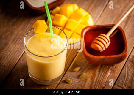 Bicchiere di mango lassi, Indiano bevanda a base di yogurt mescolato con mango e miele, aromatizzata con il cardamomo. Foto Stock