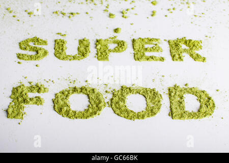 Parola super impilate di polvere verde di Erba di orzo su sfondo bianco. Foto Stock