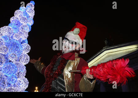 Mick Eila, un animatore di strada su palafitte, si pone di fronte al GPO su o'Connell Street di Dublino stasera durante l'accensione annuale delle luci dell'albero di Natale. Foto Stock