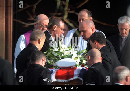 La bara del poliziotto Bill Barker arriva per i suoi funerali alla chiesa di Santa Maria e San Michele nella sua città natale di Egremont. Foto Stock