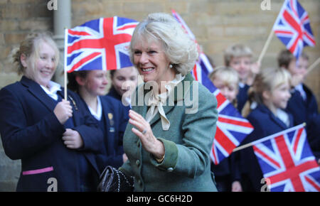 La Duchessa di Cornovaglia è accolta da bambini che sventolano bandiere quando arriva alla scuola di Westonbirt di Rose Hill vicino alla sua casa di Highgrove a Tetbury, Gloucestershire. Foto Stock