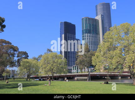 Le persone a rilassarsi a Batman Park a Melbourne in Australia. Il complesso del Crown Casinò in background. Foto Stock