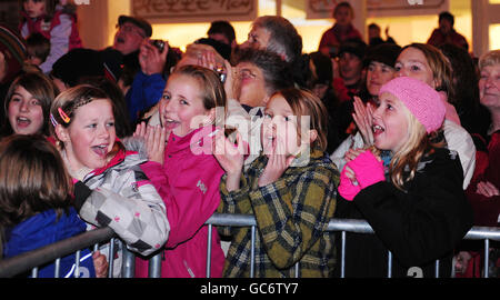 I bambini locali guardano mentre il Principe di Galles accende le luci di Natale a Keswick, durante una visita alle cittadine colpite dalle alluvioni di Cumbria. Foto Stock