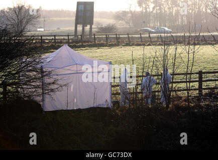 Una squadra di polizia forense indagare sulla scena in cui un corpo è stato scoperto vicino alla M80 sliproad a Pirnhall, Stirling. Foto Stock