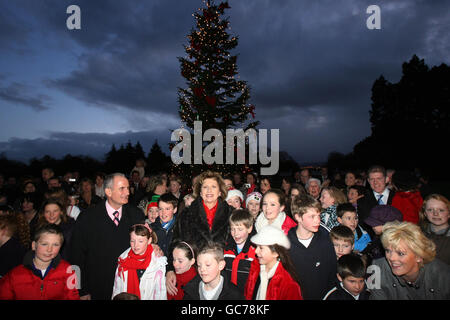 Il presidente irlandese Mary McAleese e suo marito Martin (a sinistra), si uniscono ai bambini per un servizio di carol dopo aver acceso le luci di Natale ad Aras an Uachtarain a Dublino. Foto Stock