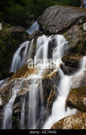 Cascate che scorrono su rocce di grandi dimensioni in un ambiente naturale. Foto Stock