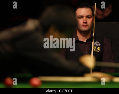 Stephen Maguire, scozzese, guarda Ding Junhui, avversario della Cina, al tavolo della sua partita semifinale durante il Pukka Pies UK Championship al Telford International Centre di Telford. Foto Stock