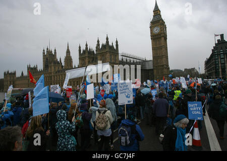 I manifestanti sul cambiamento climatico formano un'ondata di esseri umani intorno alle Camere del Parlamento nel centro di Londra, poiché decine di migliaia di persone si uniscono a manifestazioni che chiedono un'azione sul cambiamento climatico in vista dei negoziati croccanti delle Nazioni Unite a Copenaghen. Foto Stock