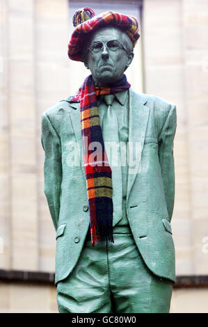 Una statua di Donald Dewar, il primo ministro della Scozia, è raffigurata con una sciarpa e un cappello Tartan in Buchanan Street, Glasgow. Foto Stock