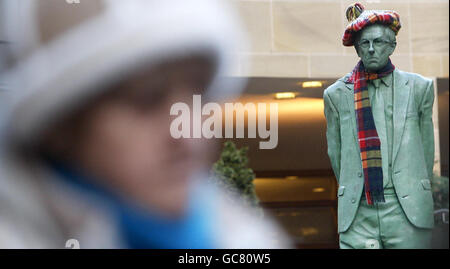 Una statua di Donald Dewar, primo ministro scozzese, è raffigurata con una sciarpa e un cappello di tartan in via Buchanan a Glasgow. Foto Stock