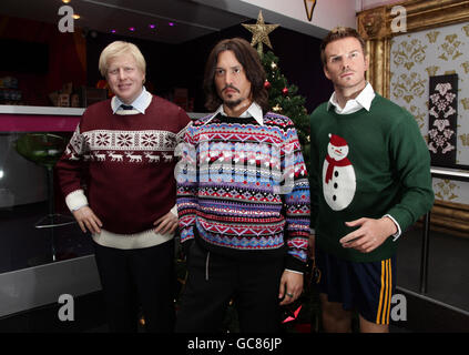 Statue celebrità di Madame Tussauds (da sinistra a destra) Boris Johnson, Johnny Depp e David Beckham, vestiti con jumper festosi. Foto Stock