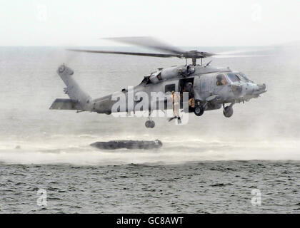 US Navy SEALS goccia nell'oceano da un HH-60H Seahawk elicottero durante la simulazione di una beach assault esercizio in corrispondenza della giunzione base Expeditionary Little Creek Luglio 17, 2010 a Fort Story, Virginia. Foto Stock