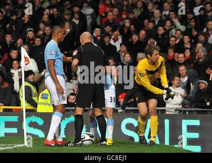 Calcio - Carling Cup - Semifinale - seconda tappa - Manchester United / Manchester City - Old Trafford. L'arbitro Howard Webb (a sinistra) controlla Craig Bellamy di Manchester City dopo che è stato colpito sulla testa con una moneta Foto Stock