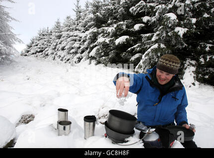 Meteo - Keith Hollis bolle neve per fare una tazza di tè - Carron Valley, Scozia Foto Stock