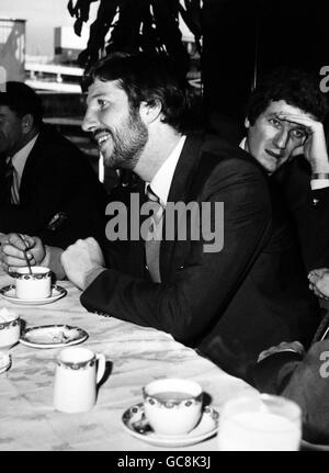 Il fast bowler Bob Willis si appoggia dietro il capitano d'Inghilterra Ian Botham Per parlare con un collega all'aeroporto di Hearthrow di Londra quando La festa di cricket dell'Inghilterra partì per un tour di tre mesi Delle Indie Occidentali Foto Stock