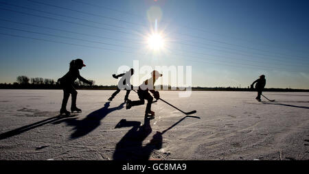 I membri del Peterborough Penguins Ice Hockey Club, a Peterborough Cambridgeshire, approfittano del Frozen Whittlesey Fen, in quanto i membri del pubblico godono delle temperature gelide a Cambridgeshire. Foto Stock