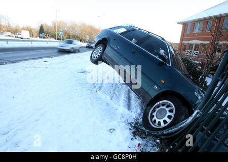 Una macchina si è schiantata fuori dalla strada A30 vicino a Egham in Surrey come la neve ha colpito il Regno Unito. Foto Stock