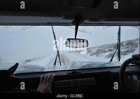 Buon samaritan Les Parr, di 49 anni, da Princetown, affronta le strade infide per andare e trainare gli abitanti di un villaggio in ciminiera casa utilizzando il suo veicolo 4x4 landrover come un fresco e pesante lotto di neve cade rapidamente nel sud-ovest del Regno Unito a Princetown, Dartmoor, Devon. Foto Stock