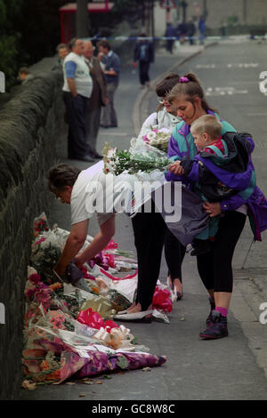 Il popolo di Sowerby Bridge porta i fiori sul luogo della tragedia di ieri, dove sei persone sono morte dopo che due veicoli si sono schiantati in edifici della città. Foto Stock