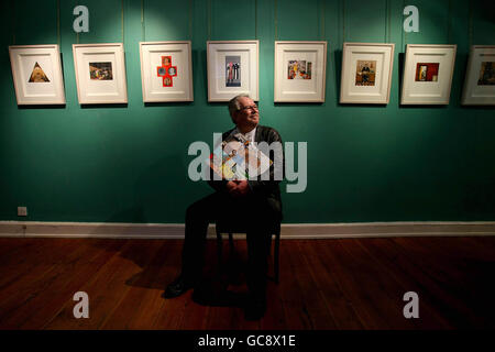 Il celebre artista irlandese Robert Ballagh siede nella Gorry Gallery, Dublino, e tiene una copia della sua biografia contenente opere d'arte originali e costa 2,500 euro ciascuna. Foto Stock