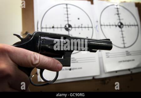 Un tecnico di NABIS (National Ballistics Intelligence Service) detiene una pistola Smith and Wesson sul campo di destinazione. Foto Stock