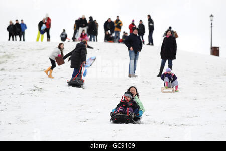 Persone che slittano sulla neve rimasta su Primrose Hill. Foto Stock