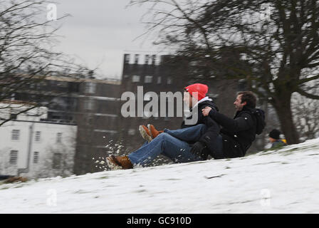 Persone che slittano sulla neve rimasta su Primrose Hill. Foto Stock