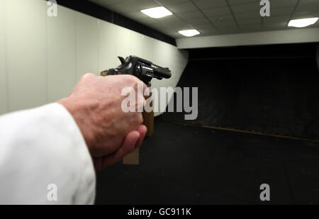 Un tecnico presso una struttura NABIS (National Ballistics Intelligence Service) punta una pistola Smith e Wesson nella gamma di test. Foto Stock