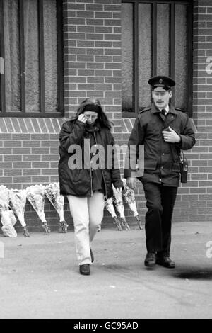 UNA GIOVANE RAGAZZA ANGOSCIATA LASCIA LA SCENA DEL MASSACRO A GRAYSTEEL, NEI PRESSI DI LONDONDERRY, DOPO AVER LASCIATO I FIORI. Foto Stock