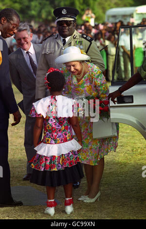 La regina Elisabetta II accetta un bouquet da una studentessa locale all'arrivo all'aeroporto di Anguilla. Foto Stock