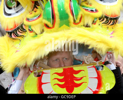 Il sindaco di Londra Boris Johnson indossa un costume da drago cinese presso una fotocellula nel quartiere di Chinatown a Londra per promuovere le celebrazioni del Capodanno cinese della capitale, che segnano l'inizio dell'anno della Tigre domenica 21 febbraio. Foto Stock