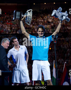 A dejected Andy Murray guarda su come Tennis Australia presidente Geoff Pollard (a sinistra) presenta la Svizzera Roger Federer con l'Australian Open Trophy in seguito alla finale dell'Australian Open a Melbourne Park, Melbourne. Foto Stock