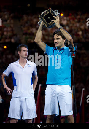 Andy Murray della Gran Bretagna si è sfidato mentre guarda Roger Federer (a destra) della Svizzera festeggia con l'Australian Open Trophy dopo la finale dell'Australian Open al Melbourne Park di Melbourne. Foto Stock