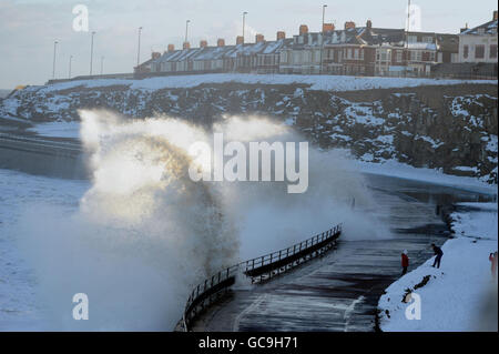 La neve e l'alto mare battono la costa nord-orientale alla spiaggia di Tynemouth, mentre si prevede che la neve fresca colpisca alcune parti della Gran Bretagna. Foto Stock