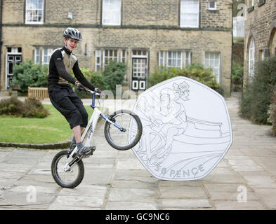 Theo Crutchley-Mack, 16 da Halifax, Posa sulla sua moto accanto a una versione gigante di un pezzo da 50 pence con il suo design di un pilota che corre una moto in un Velodrome come è stato annunciato oggi che aveva vinto un concorso nazionale scuola secondaria organizzato dalla Royal Mint per creare un Giochi Olimpici di Londra Ciclismo a tema 50p, presso la scuola di Rishworth a Halifax. Foto Stock