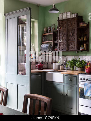 Armadio intarsiato e la rastrelliera sopra il lavabo in Nottinghill cucina, London, Regno Unito Foto Stock