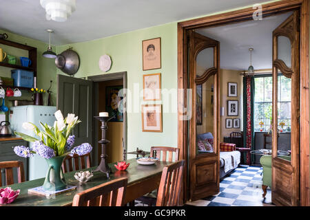 Oak sedie da pranzo con vista attraverso le doppie porte per la stanza di seduta in Nottinghill terrazza Vittoriana, London, Regno Unito Foto Stock