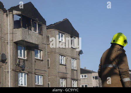 I vigili del fuoco assistono alla scena dopo lo scoppio di un incendio in un appartamento all'ultimo piano di un pianeggiante Saughton Mains Park, Edimburgo. Foto Stock