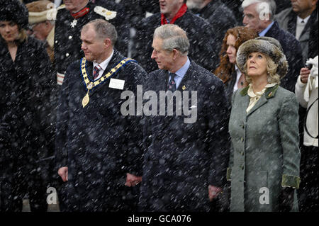 Il Principe di Galles e la Duchessa di Cornovaglia con il Sindaco Steve Bucknell in una cerimonia commemorativa al memoriale di guerra sulla High Street di Wootton Bassett, Wiltshire, durante una visita alla città. Foto Stock